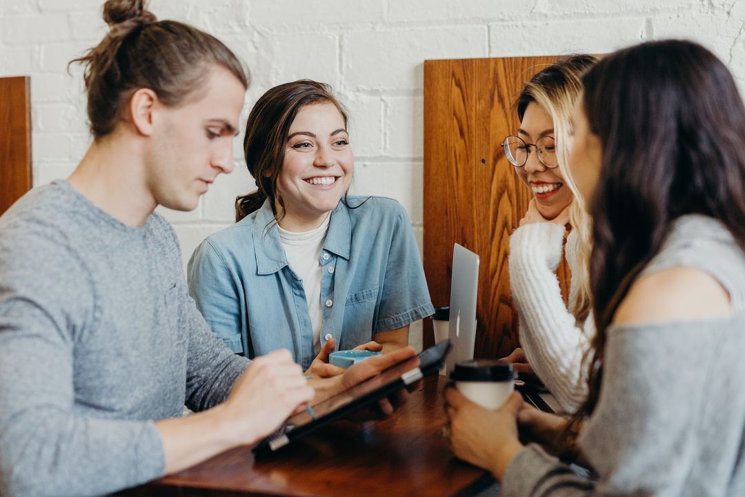 Team of colleagues having a friendly conversation in a bright modern office
