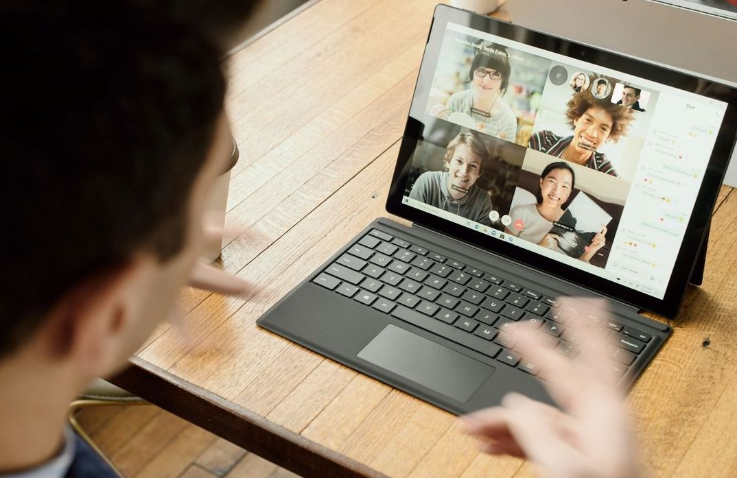 Leader facilitating a remote video meeting with distributed team members